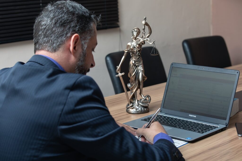 Juriste devant un ordinateur et statuette symbole de justice